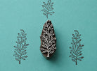 Hand carved Indian wooden block featuring delicate wild branch botanical pattern printed in black on turquoise background for textile printing, pottery, clay, and paper crafts.