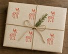 Gift wrapped package decorated with hand stamped folk deer pattern using a wood block stamp