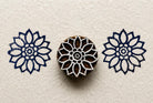 Hand carved Sunwheel wood block stamp with deep blue geometric folk art impressions on handmade paper