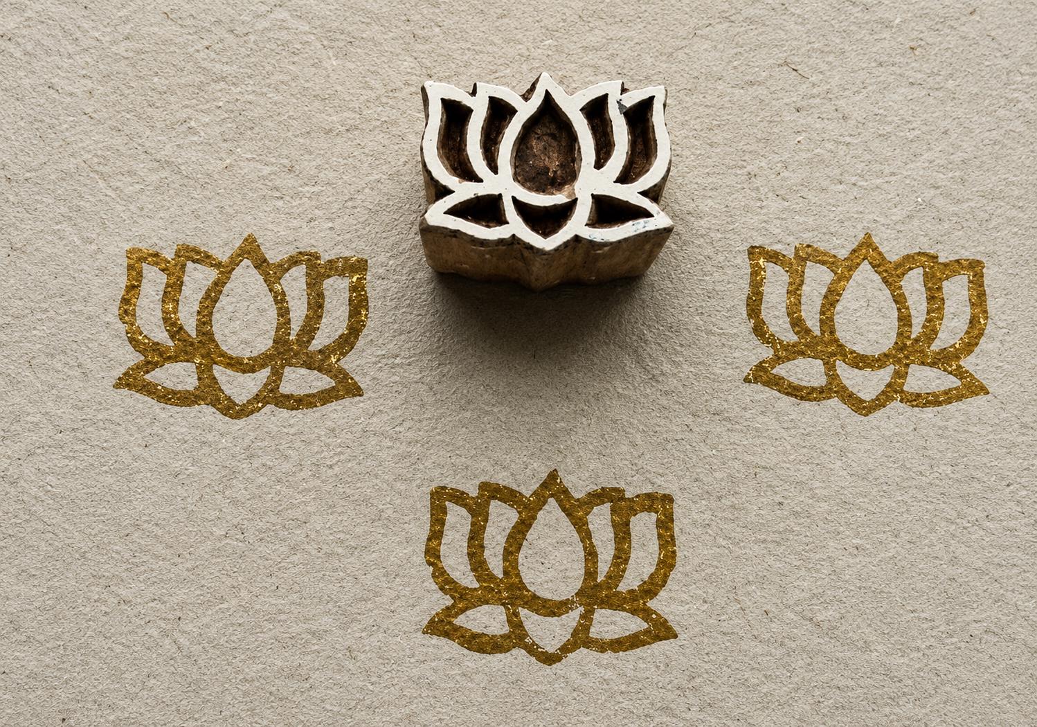 Hand carved Temple Lotus wooden block stamp with metallic gold lotus impressions on textured handmade paper.