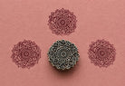 Hand carved Sacred Heart Mandala wooden block stamp with burgundy impressions on blush pink handmade paper.