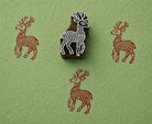 Hand carved stag deer wooden block stamp with rustic red impressions on textured green handmade paper.