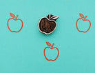 Hand carved apple wood printing block stamped in orange ink on turquoise background for fabric printing, journaling, pottery, and DIY crafts.