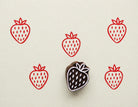 Hand carved strawberry wooden stamp with Scandinavian inspired fruit pattern printed in red ink on cream background for textile and paper crafts.
