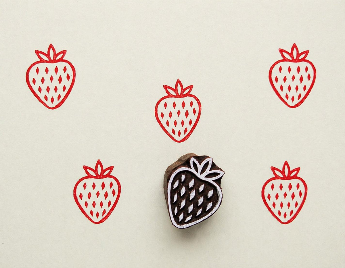 Hand carved strawberry wooden stamp with Scandinavian inspired fruit pattern printed in red ink on cream background for textile and paper crafts.