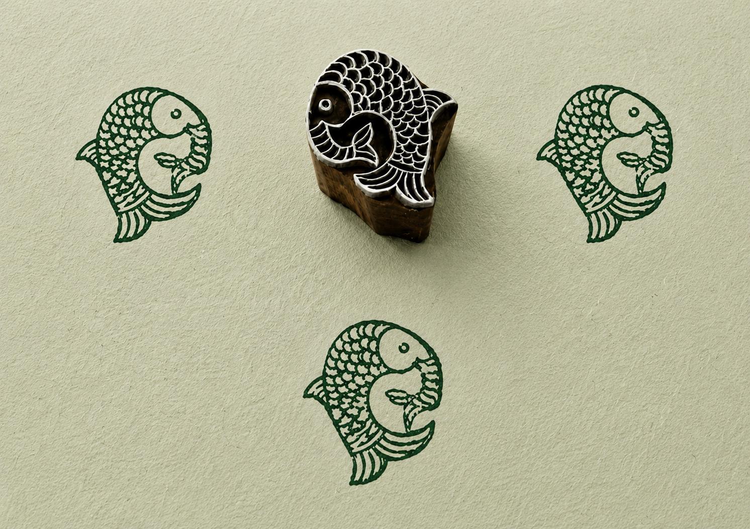 Hand carved fish printing block with decorative tribal style scales and handmade impressions