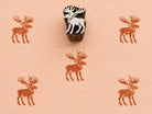 Hand carved Northern Moose wooden block stamp with rustic brown moose impressions on handmade paper.