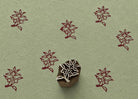 Hand carved Spring Posy wooden block stamp with burgundy floral impressions on sage green handmade paper.