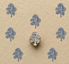 Hand carved Cloud Blossom Tree wooden block stamp with blue impressions on natural handmade paper.
