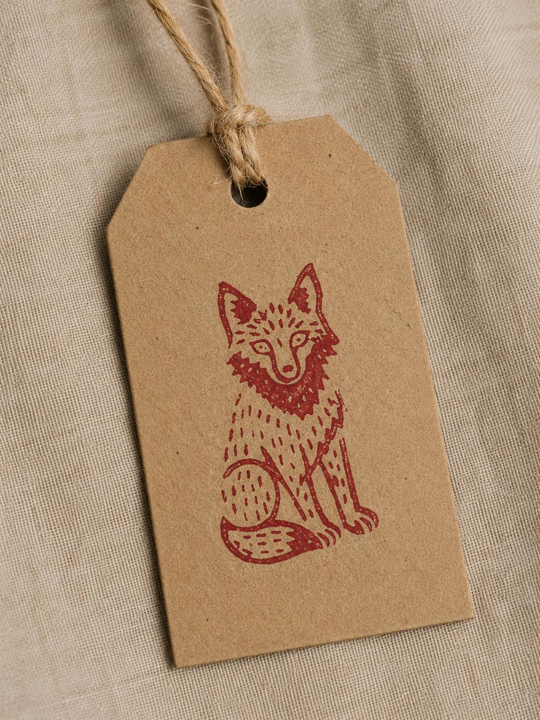 Hand stamped wolf illustration printed on a kraft gift tag tied with natural jute twine.