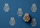 Hand carved Starlight Penguin wooden block stamp with star patterned penguin prints on deep blue handmade paper.