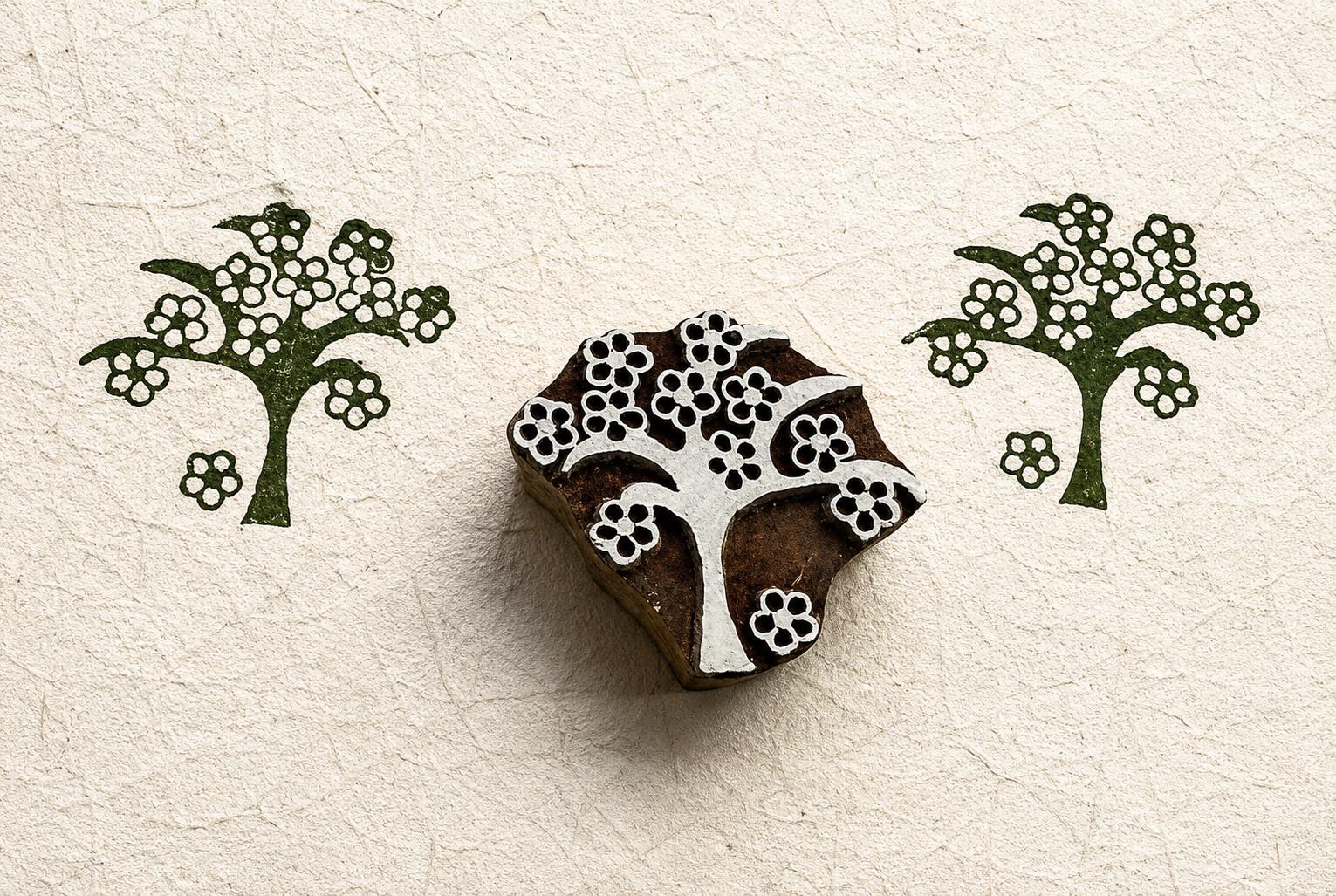 Hand carved folk blossom tree wood block stamp with repeating floral tree impressions on handmade paper