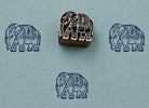 Hand carved Royal Elephant wood block stamp with blue elephant impressions on handmade textured paper