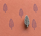 Hand-carved wooden printing block stamp featuring a minimalist leaf design with carved vein details, shown stamped in purple ink on textured terracotta handmade paper.