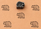 Hand carved Wandering Bear wooden block stamp with brown bear impressions on handmade paper.