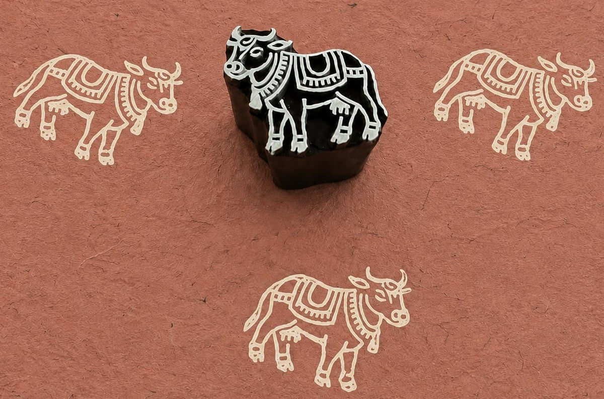 Hand carved Ceremonial Cow wooden block stamp with ivory impressions on terracotta handmade paper.