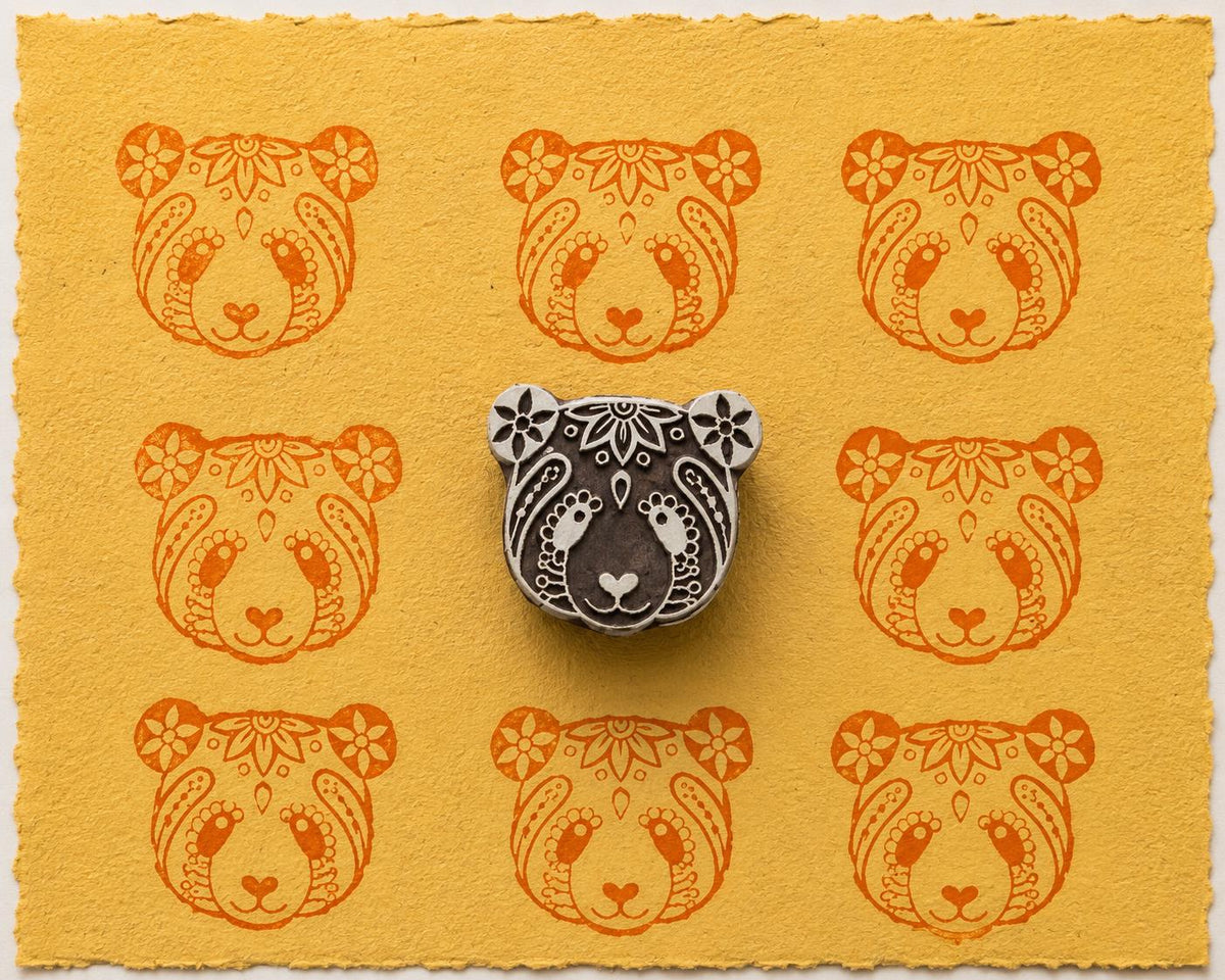 Hand carved Floral Panda wooden printing block displayed with orange panda impressions on handmade yellow paper.
