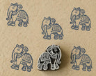 Hand-carved wooden Indian elephant printing block with repeated navy blue elephant impressions on handmade paper, traditional textile stamp.