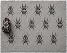 Hand carved Tribal Beetle wooden printing block with geometric beetle pattern printed on textured handmade grey paper.