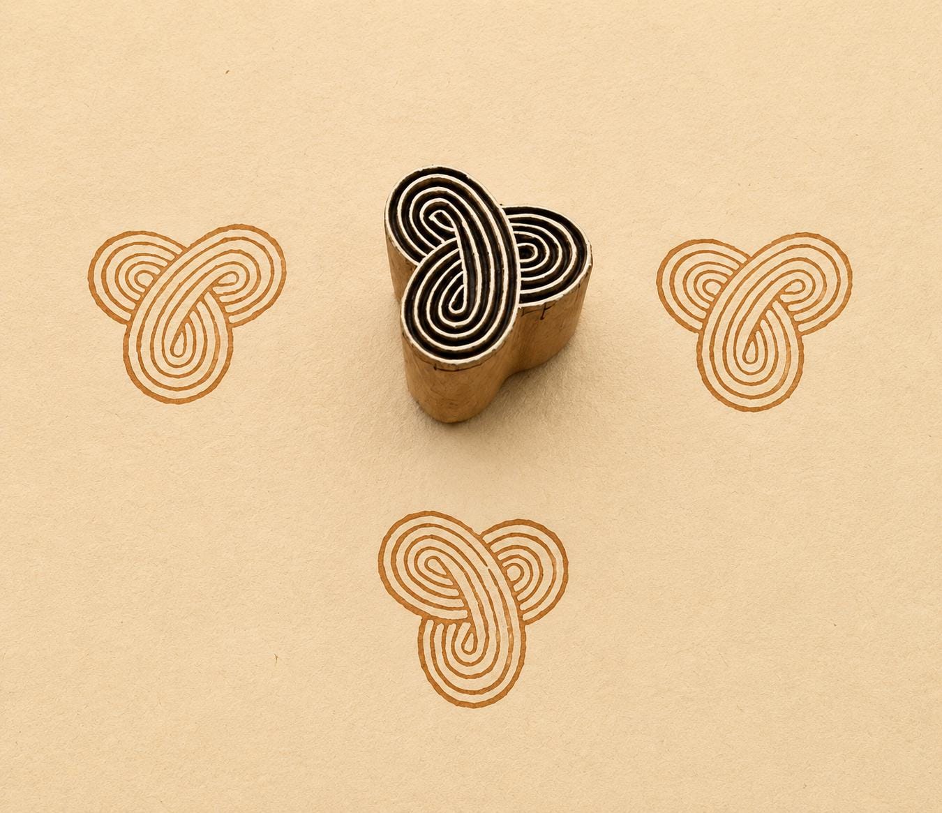 Hand carved Infinity Knot wooden printing block with interlocking geometric pattern printed on handmade paper for fabric printing, textile design, pottery, clay and paper crafts.