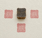 Hand carved Indian wooden textile printing block featuring a Ripple Bloom geometric motif with concentric wavy lines and a floral center, stamped in red on handmade paper.