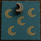 Hand-carved Ornate Crescent Moon wooden printing block with golden crescent moon impressions on textured blue handmade paper.