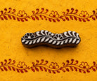Hand-carved wooden printing block for creating a repeating wedding garland border on fabric and handmade paper.