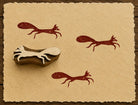 Hand-carved Fox on the Run wooden printing block with rustic brown fox impressions on textured handmade paper.