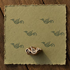 Hand-carved Folk Sparrow wood block stamp with sage green sparrow impressions on handmade textured paper.
