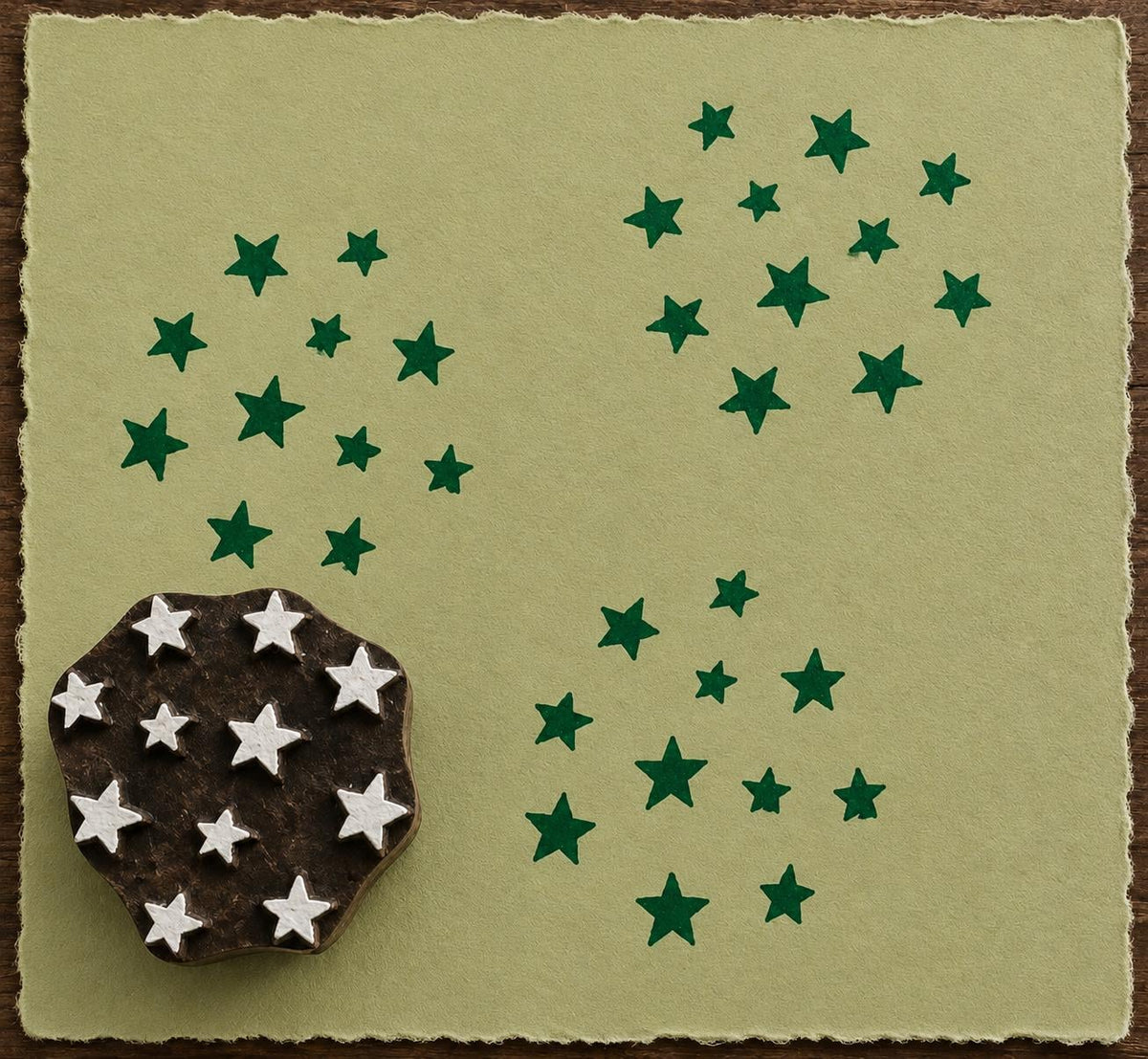 Hand-carved Starfall wood block stamp creating scattered green star impressions on handmade sage paper.