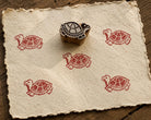 Hand carved turtle wood block stamp with red turtle print on handmade paper, ideal for fabric printing, pottery, clay, paper and textile crafts.