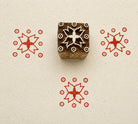 Hand carved Indian wooden textile printing block featuring a Temple Star floral motif with circular accents, stamped in red on handmade paper.