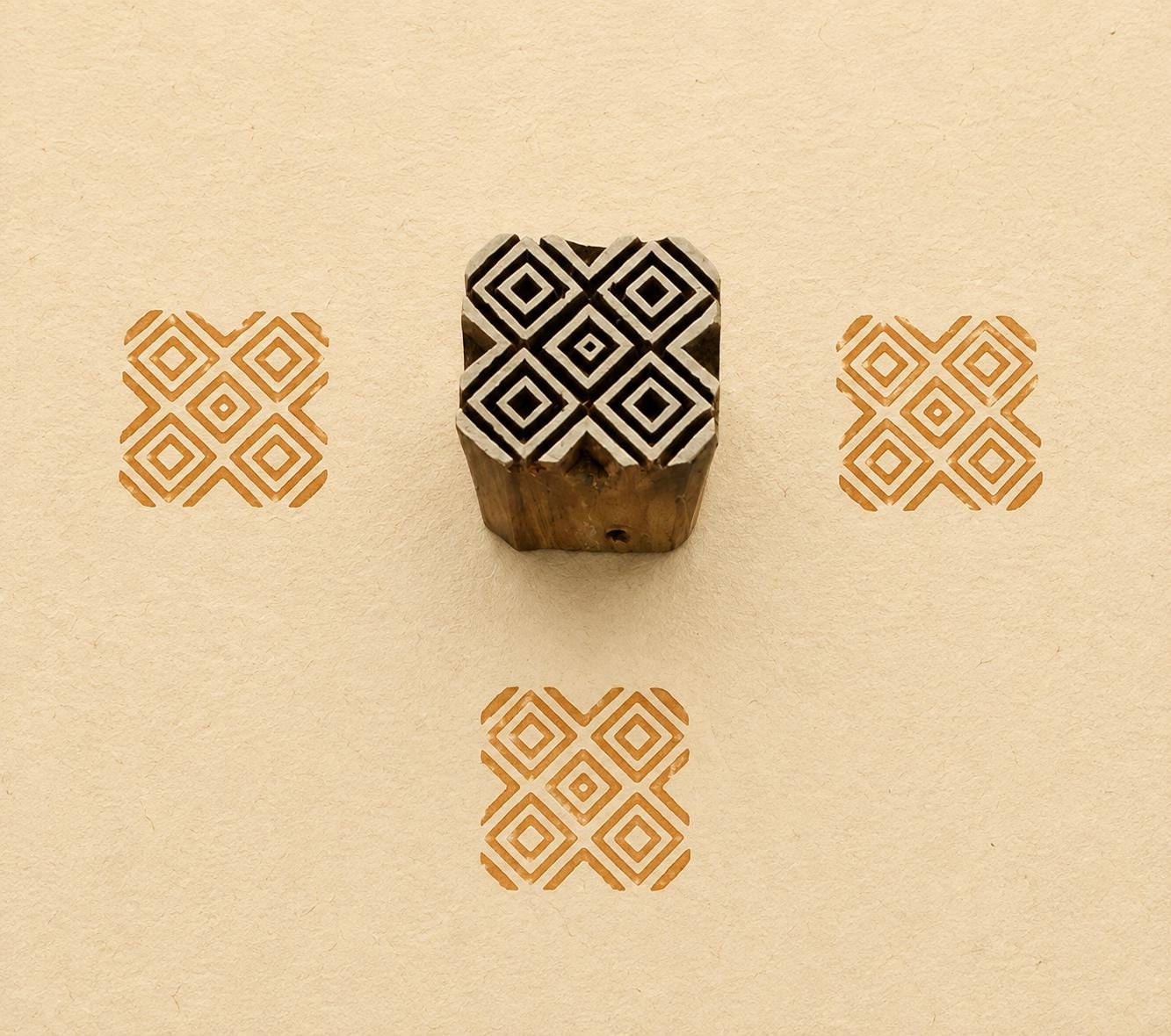 Hand carved Indian wooden textile printing block featuring a Temple Diamonds geometric pattern with nested diamonds, stamped in ochre on handmade paper.