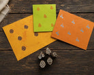 Set of five tiny hand carved Indian wood printing blocks with evergreen, pinecone, mushroom, acorn and twin cherry motifs, shown with stamped paper samples