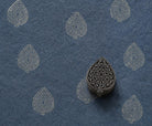 Ornate Teardrop wooden stamp shown on textured navy handmade paper with repeated antique-gold impressions.