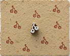 Tiny hand carved cherry pair wooden printing block stamped in red pink ink on textured handmade paper for fabric printing, journaling, and craft projects.