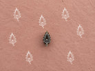 Hand carved Beaded Paisley wooden printing block with repeated paisley impressions on textured dusty pink handmade paper