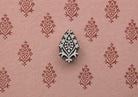 Crowned Diamond hand carved Indian wood printing block creating a repeating ornamental diamond pattern on pink handmade paper