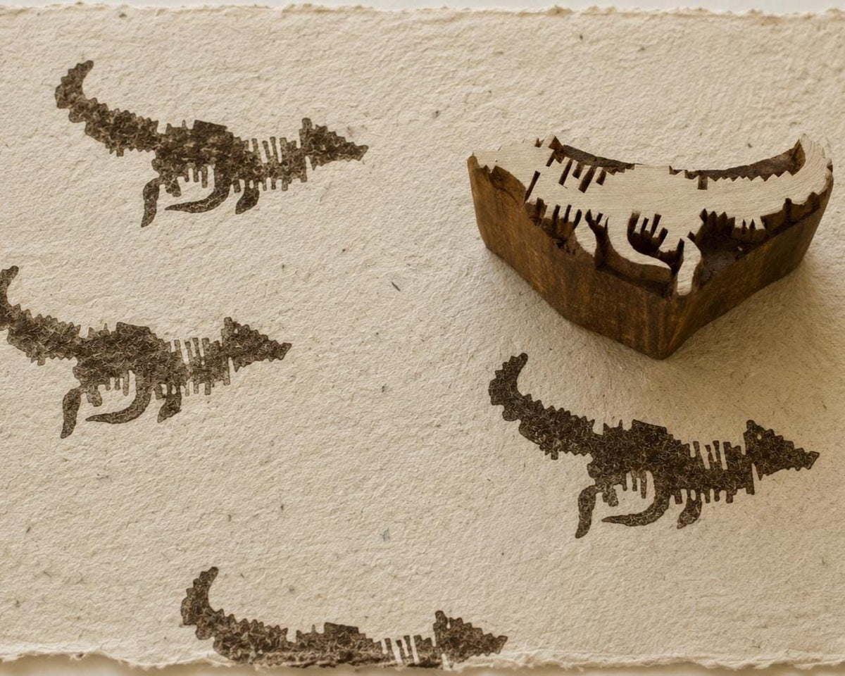 Hand carved Fox in Motion wooden printing block with repeated running fox impressions on textured handmade paper