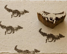 Hand carved Fox in Motion wooden printing block with repeated running fox impressions on textured handmade paper