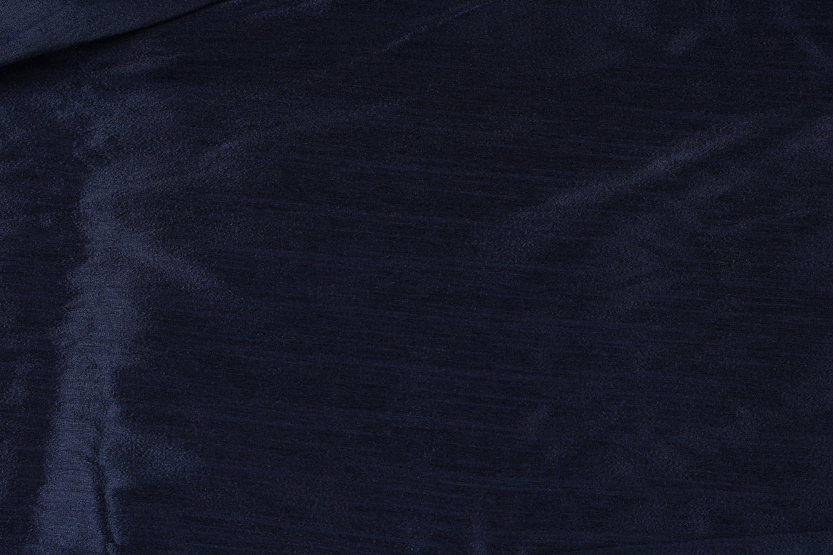 Midnight navy polyester dupioni fabric gathered in the centre, showing its elegant drape and subtle textured finish.