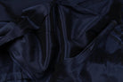 Deep midnight navy faux dupioni fabric draped in soft folds to show its texture and rich dark blue colour.