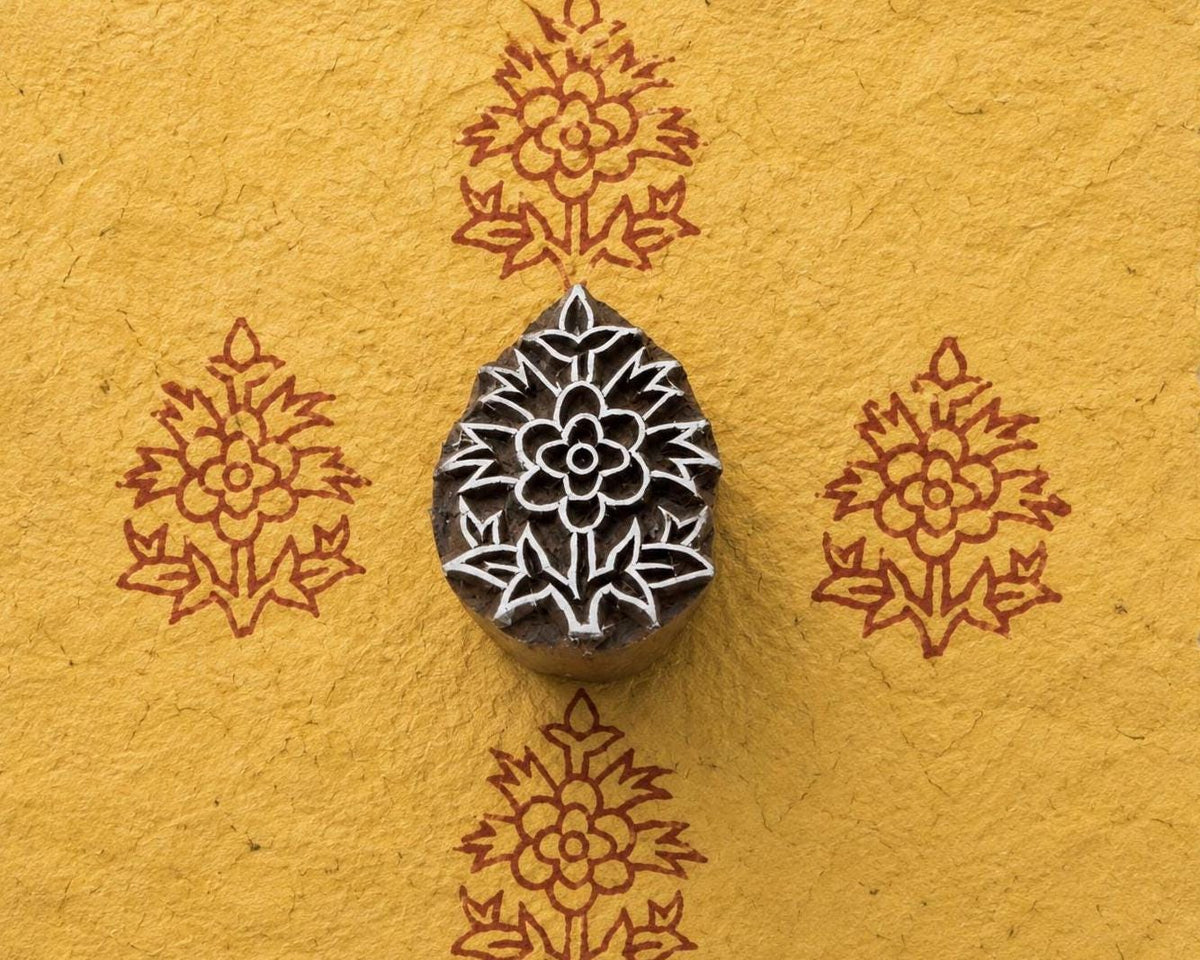 Regal Blossom hand carved Indian wood printing block shown creating a repeating blossom motif on golden handmade paper