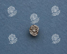 Hand-carved Wildflower Spray wooden printing block with delicate white botanical prints on textured dark blue handmade paper.