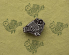 Carved decorative bird woodblock with repeating green bird prints on handmade paper