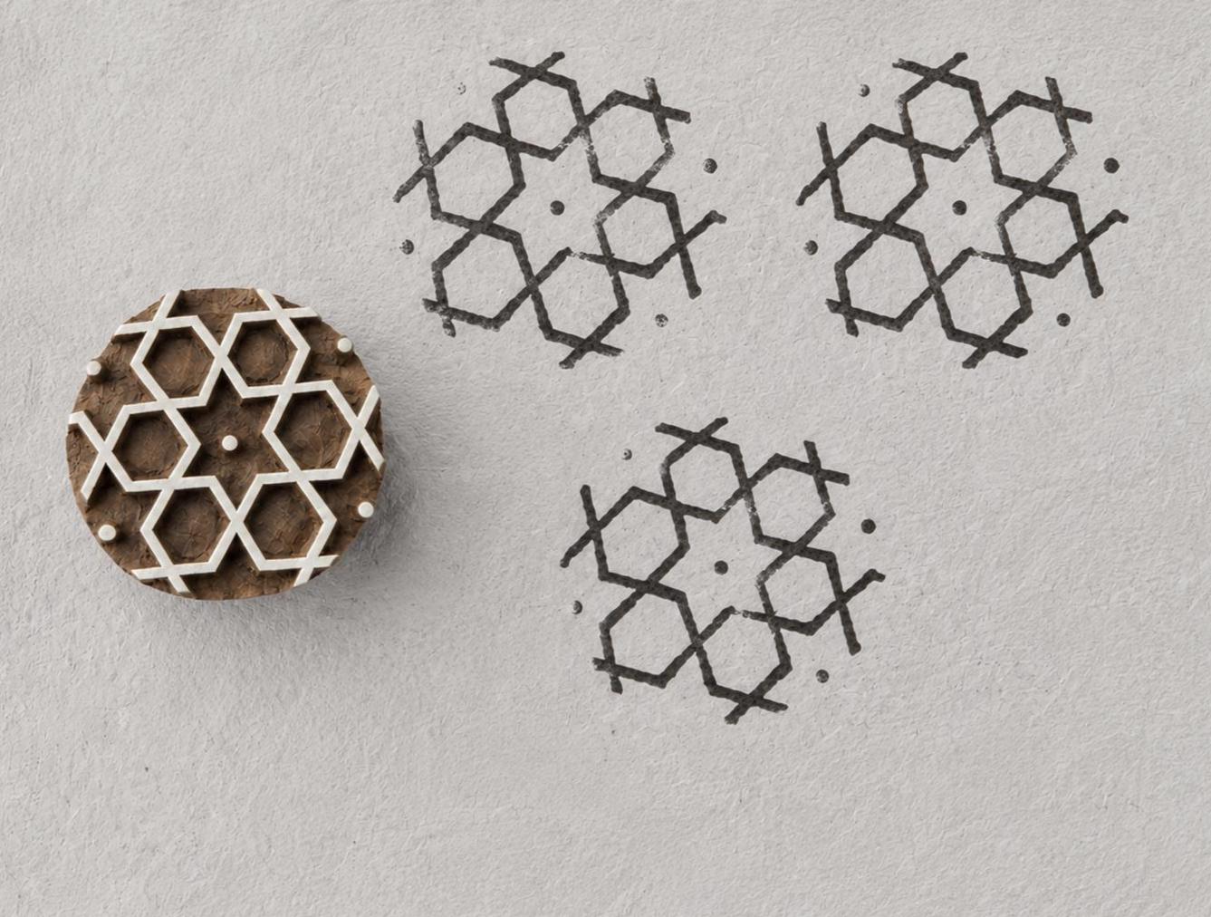 Interlocking hexagon geometric wood block stamp with repeated handmade impressions on paper