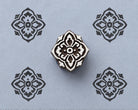 Ornamental quatrefoil wood block stamp with repeated tile pattern impressions on handmade paper