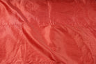 Vibrant red faux dupioni fabric draped to show the soft folds and texture