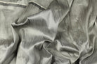 Silver grey faux dupioni fabric arranged in folds, highlighting its silk-like lustre and subtle texture.