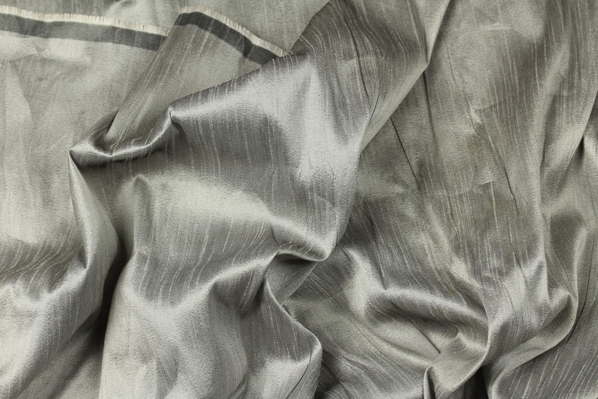 Silver grey faux dupioni fabric arranged in folds, highlighting its silk-like lustre and subtle texture.
